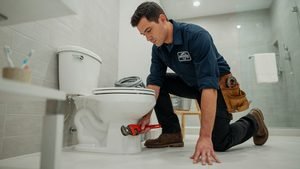 Food coloring being added to a toilet tank as part of a monthly leak test.