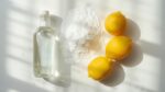 Organized display of natural cleaning ingredients including white vinegar, baking soda, and lemons